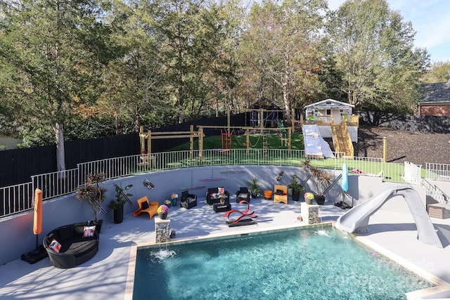 view of swimming pool featuring pool water feature, a water slide, and a patio area