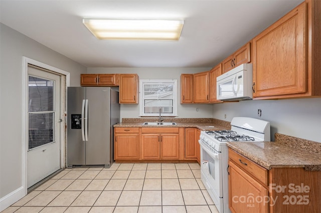 kitchen featuring sink, white appliances, and light tile patterned flooring