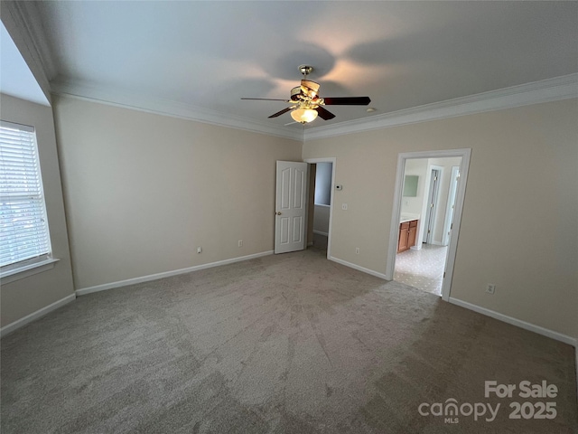 interior space with a ceiling fan, light carpet, crown molding, and baseboards