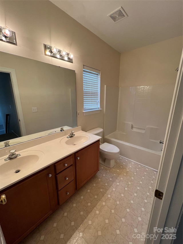 bathroom with visible vents, a sink, toilet, and double vanity