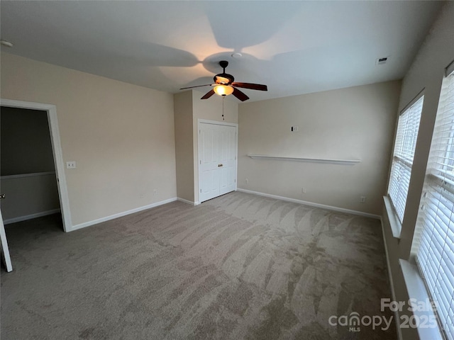 unfurnished bedroom featuring a ceiling fan, baseboards, and carpet flooring