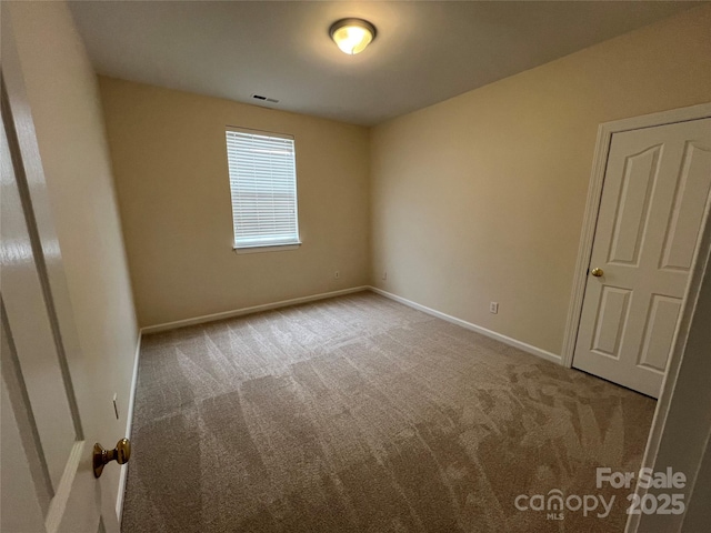 unfurnished bedroom featuring baseboards, visible vents, and light colored carpet