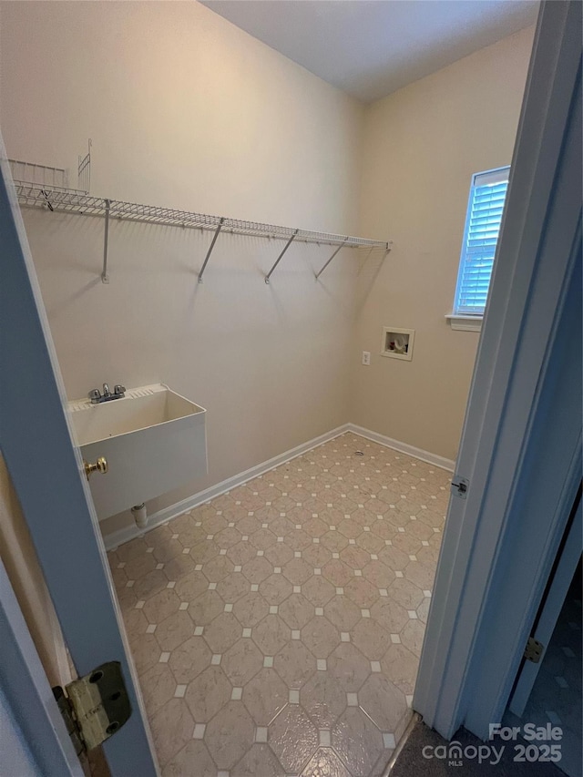 clothes washing area with laundry area, hookup for a washing machine, and baseboards