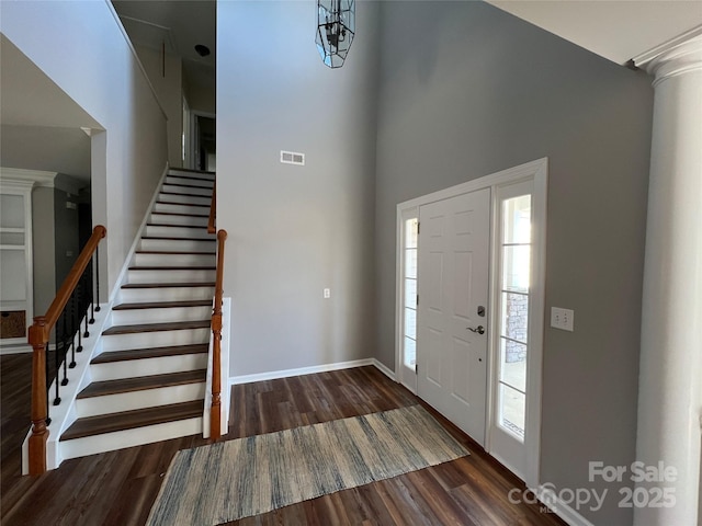 entrance foyer featuring dark wood-style floors, visible vents, plenty of natural light, and stairs