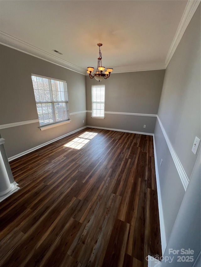 unfurnished dining area with crown molding, a notable chandelier, visible vents, dark wood-type flooring, and baseboards