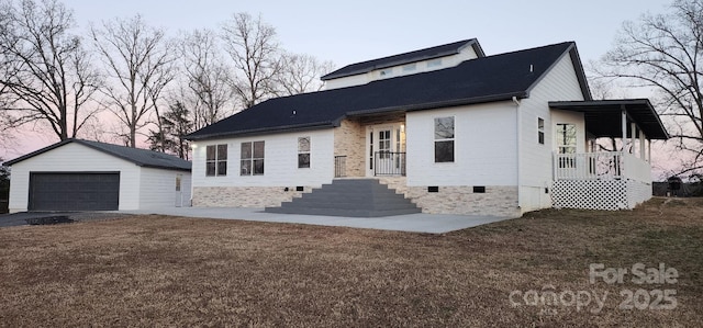 view of front of home with a garage, an outdoor structure, and a lawn