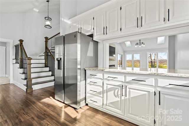 kitchen featuring white cabinetry, light stone counters, stainless steel fridge, and dark hardwood / wood-style floors