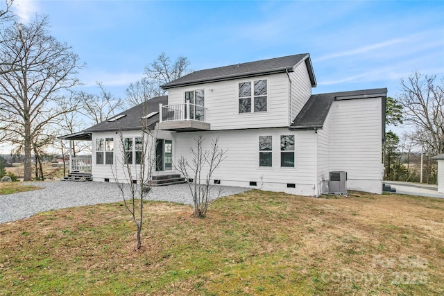 rear view of property featuring central AC unit, a lawn, and a balcony