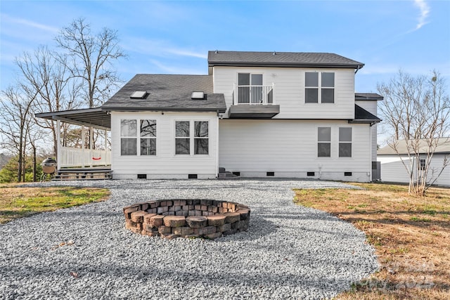 back of property with a balcony and a fire pit