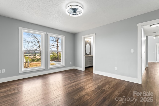 unfurnished room featuring dark hardwood / wood-style floors and a textured ceiling