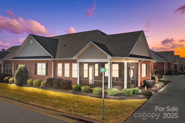 craftsman house featuring a sunroom and a yard