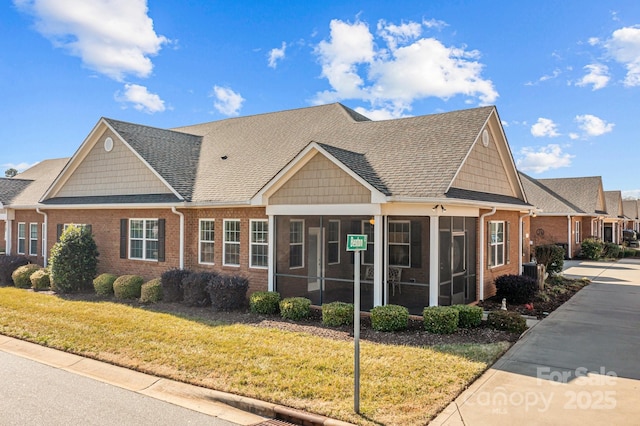 craftsman-style house with a sunroom, central air condition unit, and a front lawn