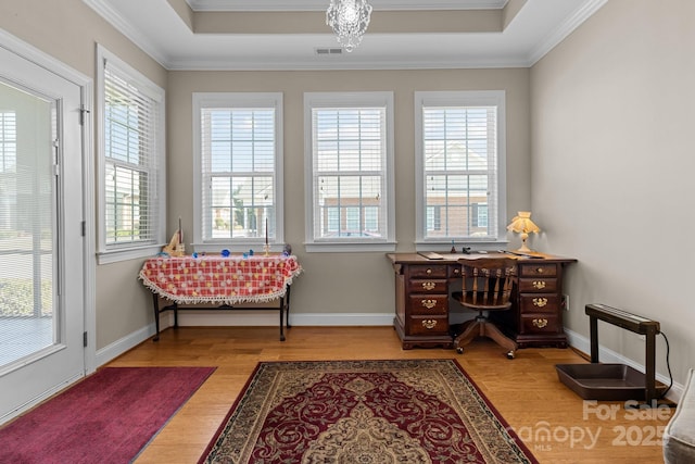 living area featuring a tray ceiling, ornamental molding, and hardwood / wood-style flooring