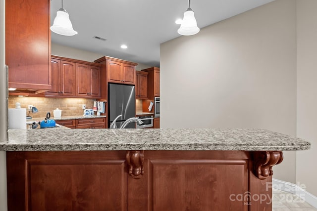 kitchen featuring tasteful backsplash, hanging light fixtures, stainless steel appliances, and kitchen peninsula