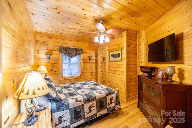 bedroom featuring wooden walls, wood ceiling, and light hardwood / wood-style floors