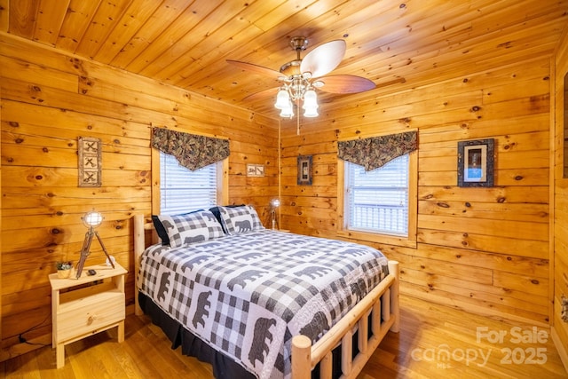 bedroom with wood-type flooring, wooden walls, and wood ceiling