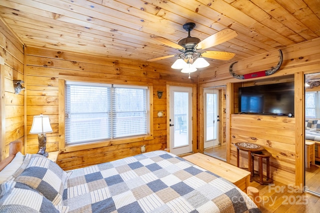 bedroom with wood ceiling, wooden walls, and light hardwood / wood-style floors