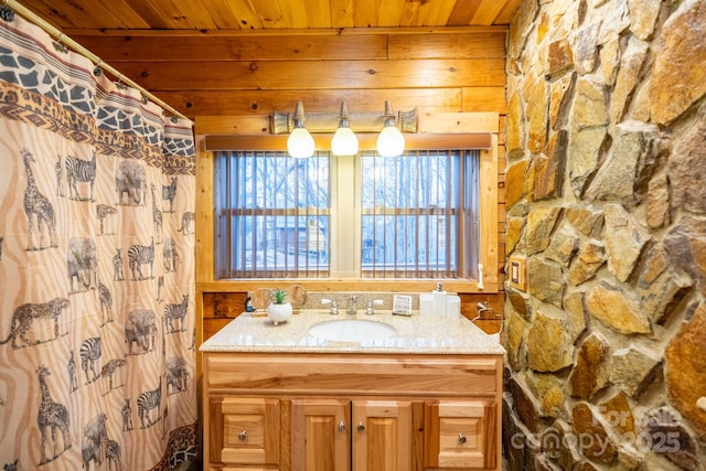 bathroom with vanity, wood ceiling, and a healthy amount of sunlight