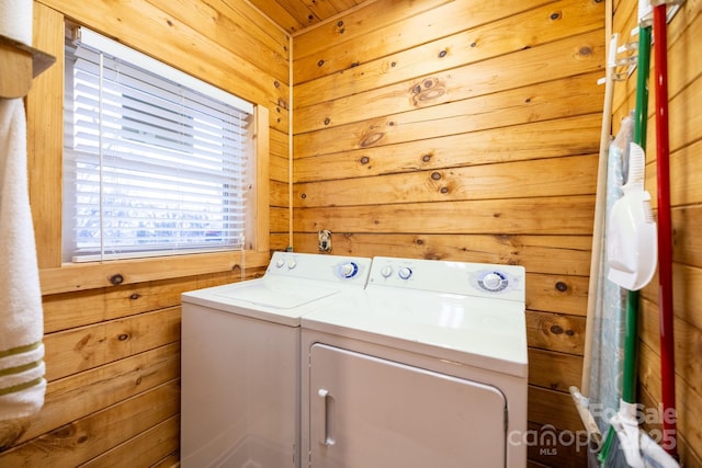 laundry room with wooden walls and washing machine and dryer