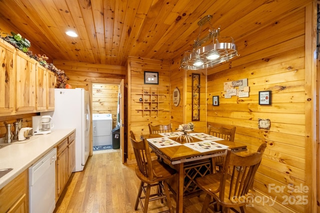 dining space with washer / clothes dryer, wood ceiling, wood walls, and light wood-type flooring