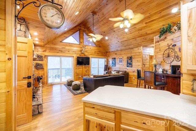 kitchen featuring vaulted ceiling, wooden walls, ceiling fan, wood ceiling, and light wood-type flooring