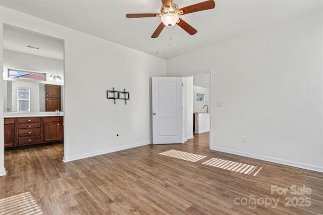 unfurnished bedroom featuring ceiling fan, connected bathroom, and light hardwood / wood-style floors