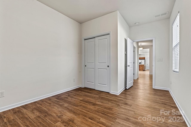 unfurnished bedroom with wood-type flooring and a closet