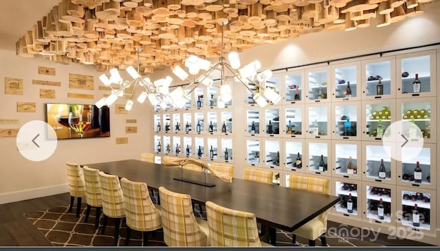 wine area with dark hardwood / wood-style floors and a chandelier