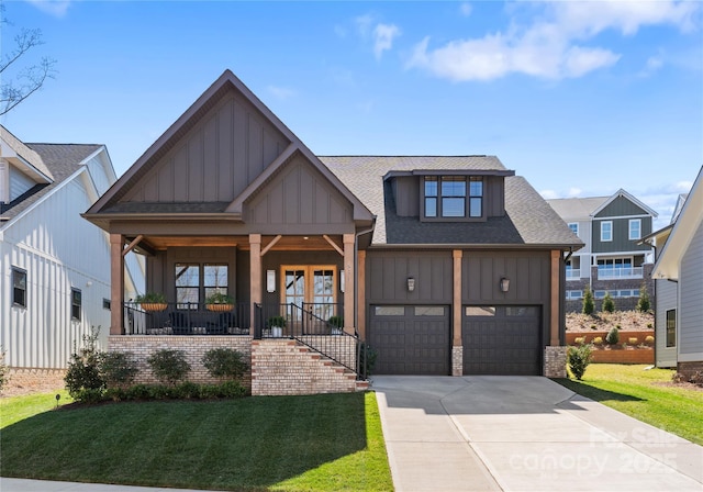 view of front of home featuring a front yard, covered porch, board and batten siding, and driveway