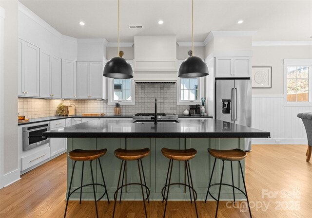 kitchen featuring visible vents, dark countertops, appliances with stainless steel finishes, and light wood finished floors