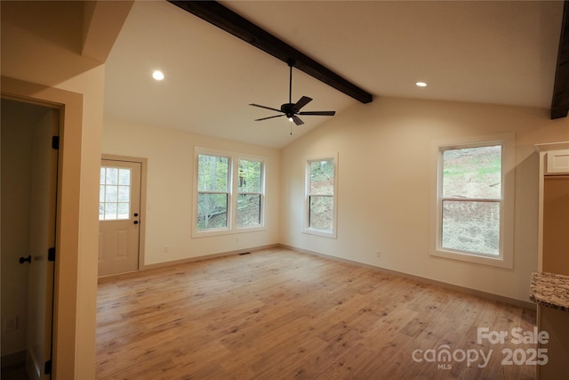 interior space featuring baseboards, ceiling fan, vaulted ceiling with beams, and light wood finished floors