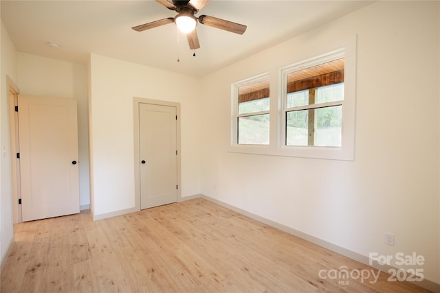 unfurnished bedroom featuring light wood-style floors, baseboards, and ceiling fan