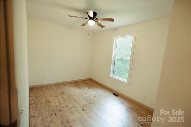 spare room with visible vents, light wood-style flooring, ceiling fan, and baseboards