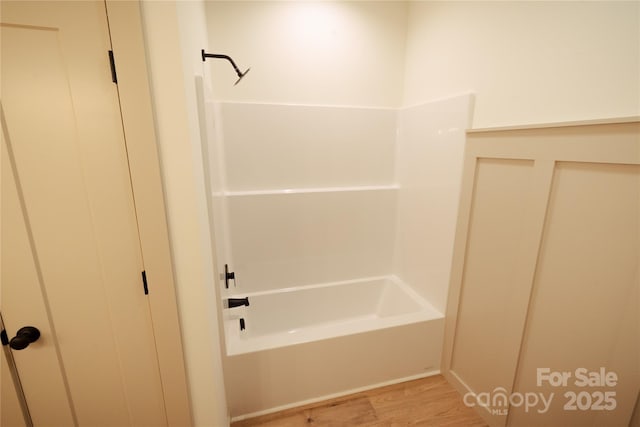 full bath featuring  shower combination and wood finished floors