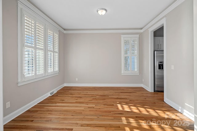 empty room with ornamental molding and light hardwood / wood-style flooring