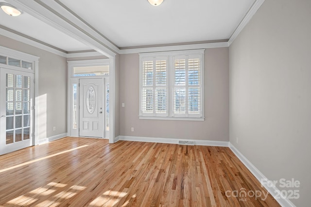 entrance foyer featuring crown molding and light wood-type flooring