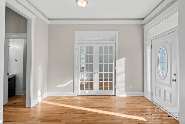 foyer featuring hardwood / wood-style flooring, crown molding, and french doors