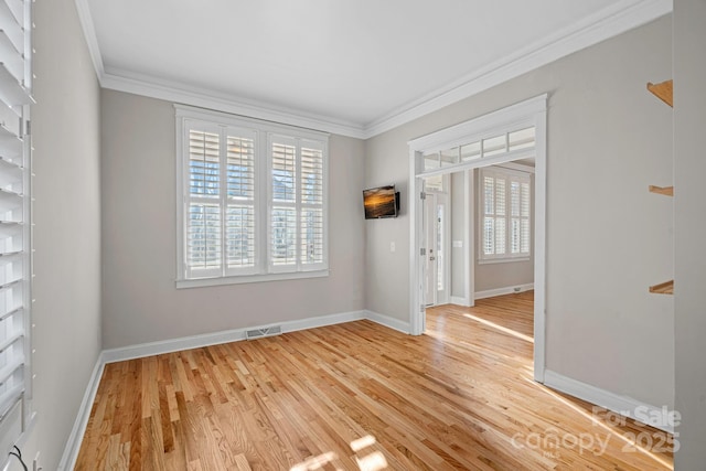 spare room with crown molding and light hardwood / wood-style flooring