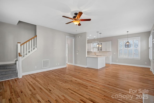 unfurnished living room featuring ceiling fan and light hardwood / wood-style flooring