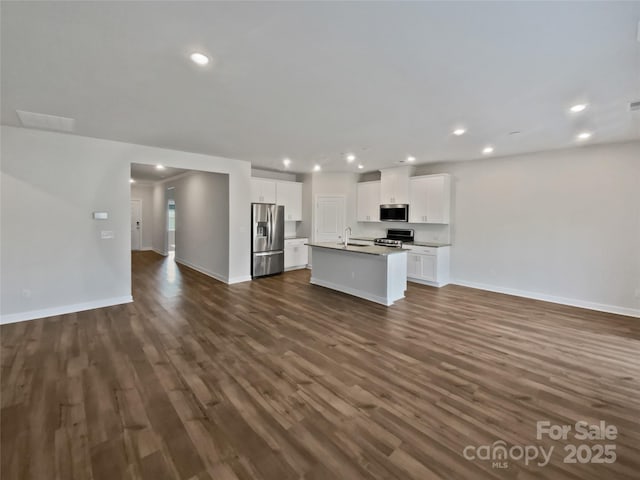 kitchen featuring sink, appliances with stainless steel finishes, white cabinetry, a center island with sink, and dark hardwood / wood-style flooring