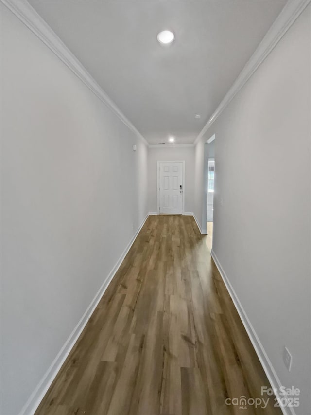 corridor with ornamental molding and hardwood / wood-style floors