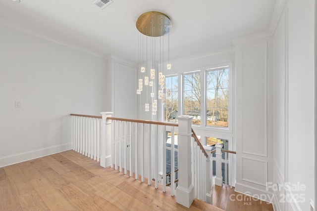 stairs featuring hardwood / wood-style flooring and crown molding