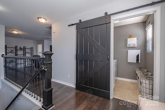 entrance foyer with dark wood-type flooring and a barn door