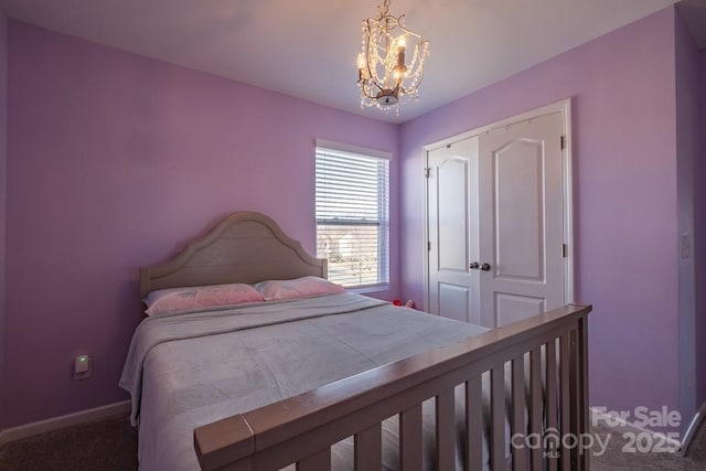 carpeted bedroom featuring an inviting chandelier and a closet