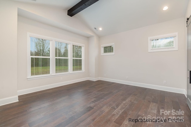 empty room featuring lofted ceiling with beams, a barn door, and dark wood-type flooring