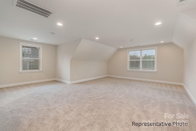 bonus room featuring vaulted ceiling and light colored carpet