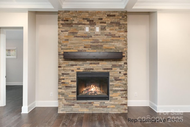 room details with ornamental molding, a stone fireplace, and hardwood / wood-style floors