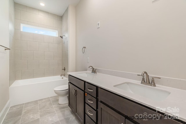 full bathroom with vanity, tiled shower / bath, and toilet