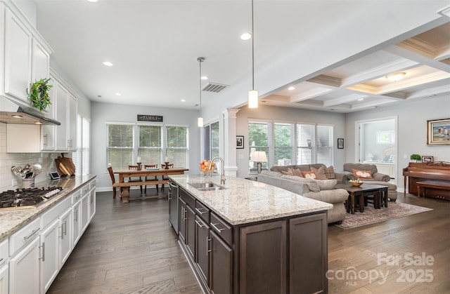 kitchen with sink, dark brown cabinets, hanging light fixtures, appliances with stainless steel finishes, and white cabinets