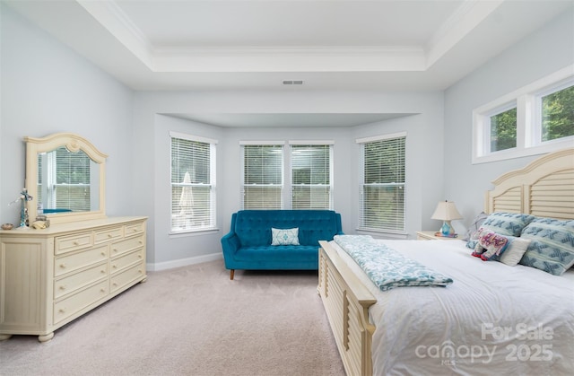 bedroom featuring light carpet, ornamental molding, and a raised ceiling